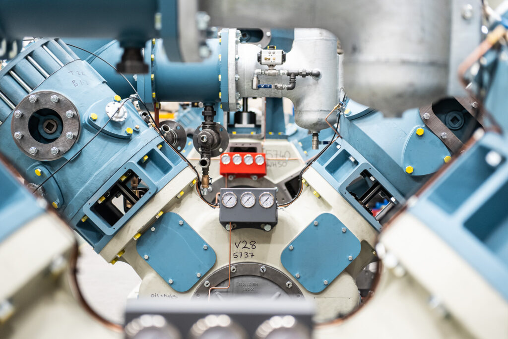 Industrial Photography of an industrial compressor in a factory, with another industrial compressor unit in the background