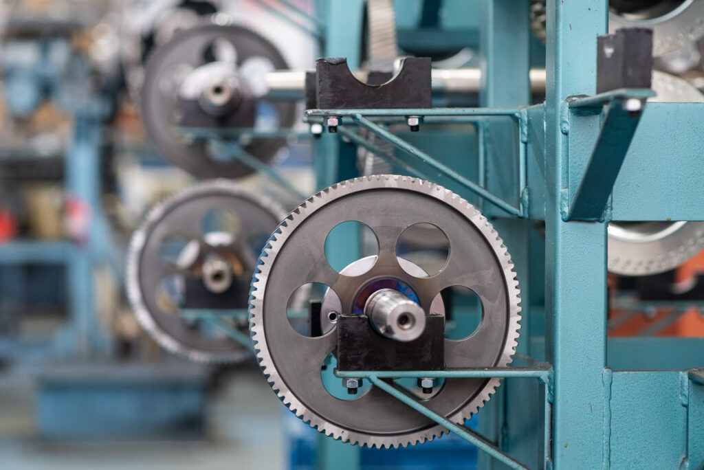 Industrial photography of metallic components sitting on a rack in a factory