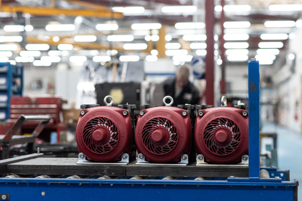 Industrial photography of compressor units in a manufacturing facility.